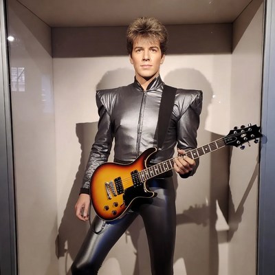 Man in shiny outfit holding guitar