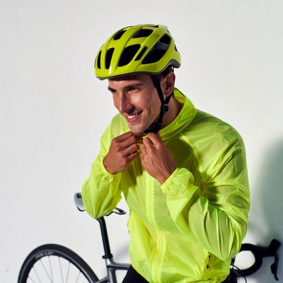 Man wearing yellow helmet and jacket with bike