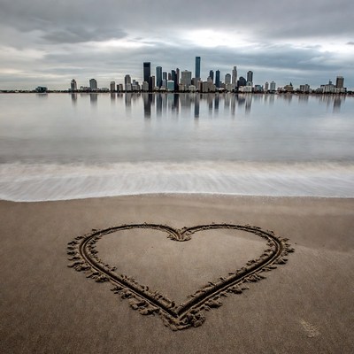 Heart in Sand with City Skyline Reflection