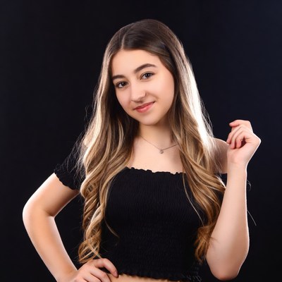 Teen girl smiling on black background