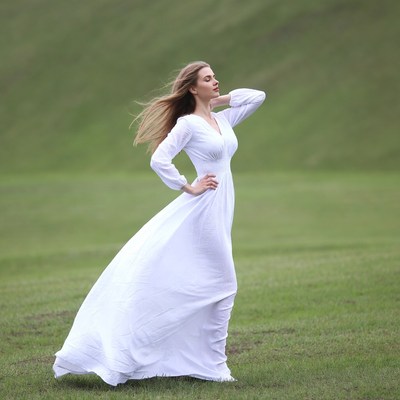 Woman in white dress on green field
