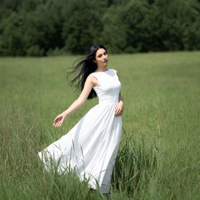 Woman in white dress in green field