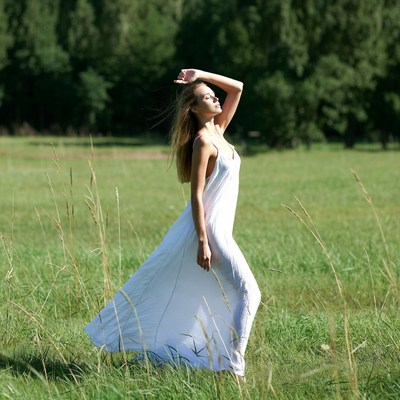 Woman in white dress in grassy field