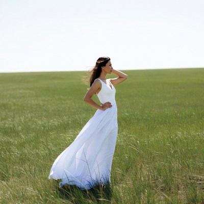 Woman in white dress in green field