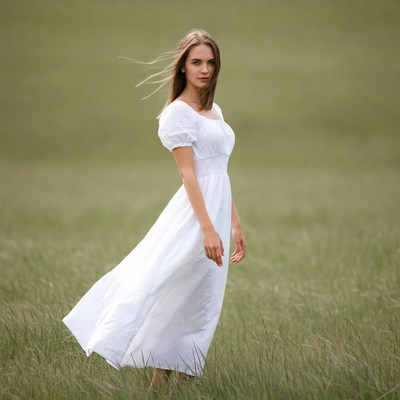 Woman in white dress in green field