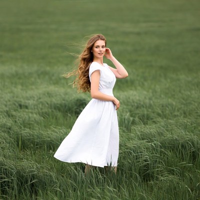 Woman in white dress in green field