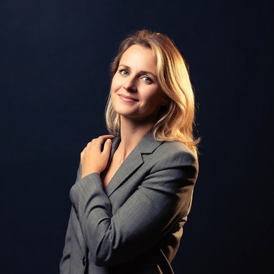Blonde woman in gray suit smiling