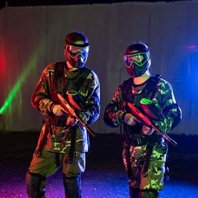 Man and Woman in Camo Paintball Gear