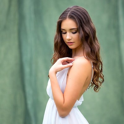 Young woman in white dress side profile