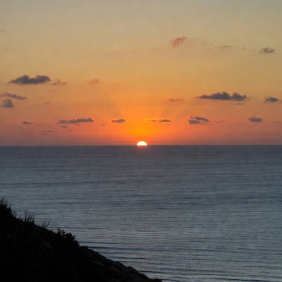 Sunset over ocean from cliff