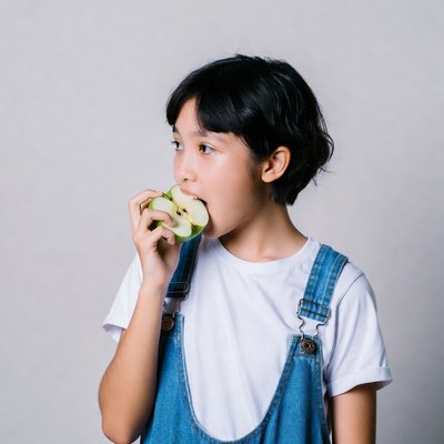 Asian girl eating green apple