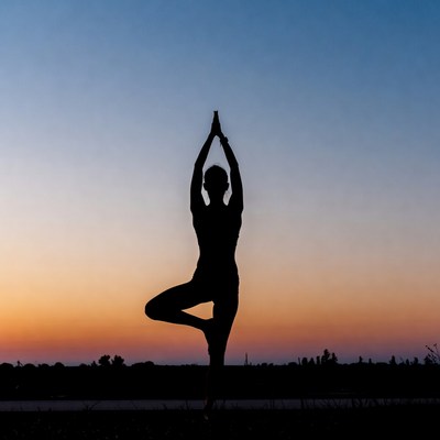 Woman in tree pose yoga silhouette sunset