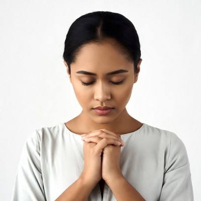 Asian woman praying with hands clasped