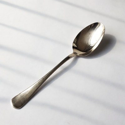 Shiny silver spoon on sunlit surface