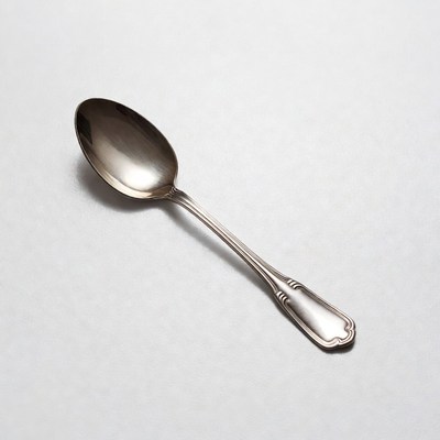 Shiny silver spoon on white background