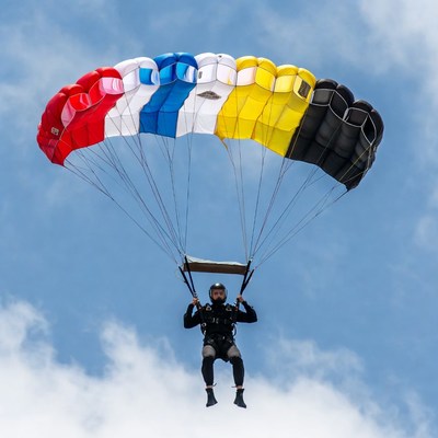 Man skydiving with colorful parachute