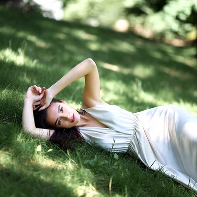 Woman lying on grass in white dress