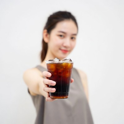 Asian woman holding iced coffee