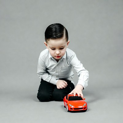 Boy playing with red toy car