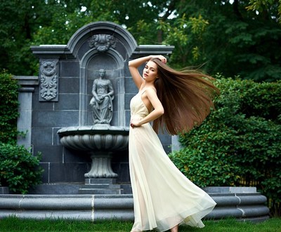 Woman in flowing white dress by fountain