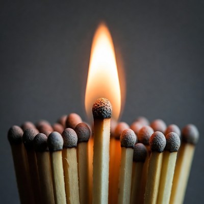 Lit match surrounded by matches