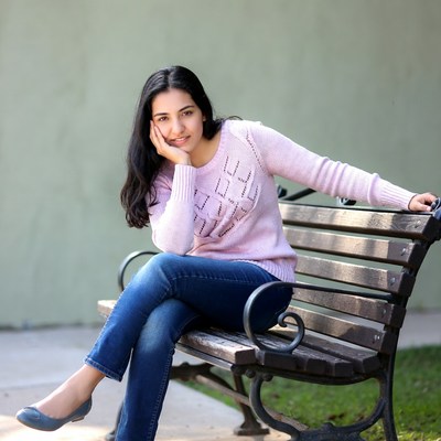 Young woman resting chin on park bench