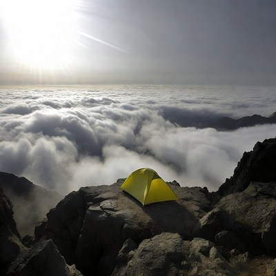 Yellow tent on mountain above clouds