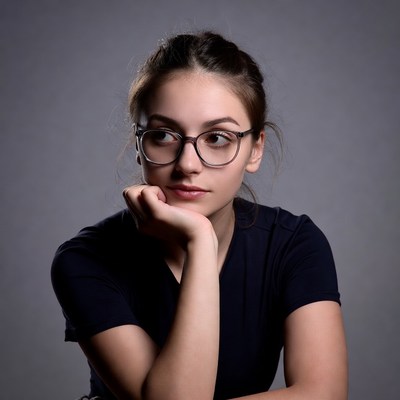Young woman with glasses thoughtful pose