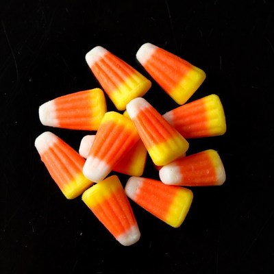 Candy corn pile on black background