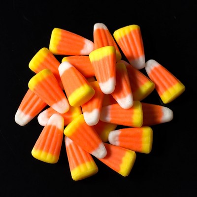 Candy corn pile on black background