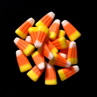 Candy corn pile on black background