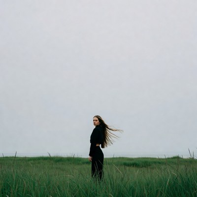 Woman standing in tall grass field
