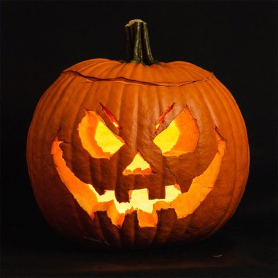 Lit Jack-o'-lantern pumpkin on black background