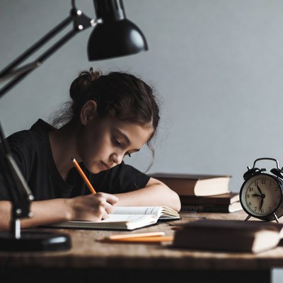 Girl studying at desk with lamp