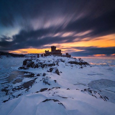 Medieval Castle on Snowy Cliff at Sunset