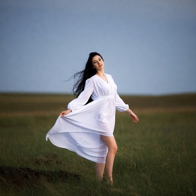 Woman in white dress in grassy field