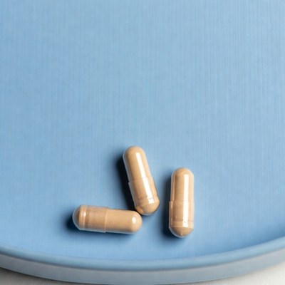 Three beige capsules on blue plate