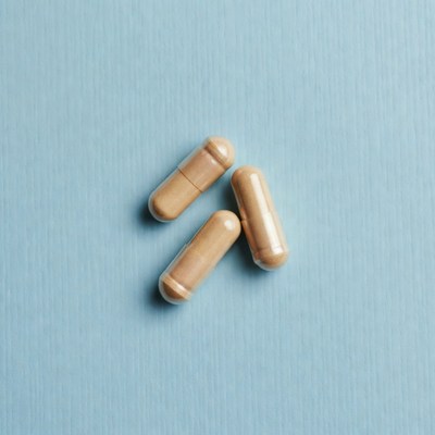 Three beige capsules on blue background