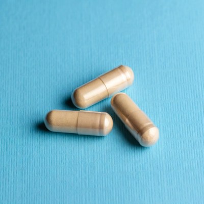 Three beige capsules on blue background