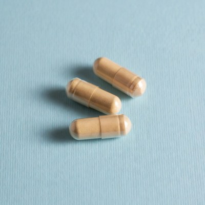 Three beige capsules on blue background