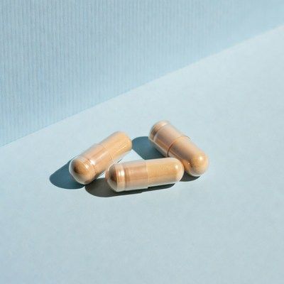 Three beige capsules on blue background