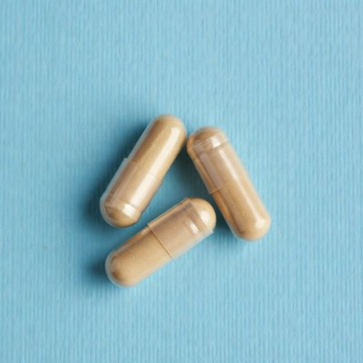 Three beige capsules on blue background