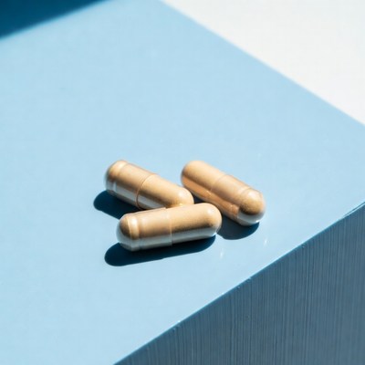 Three beige capsules on blue surface