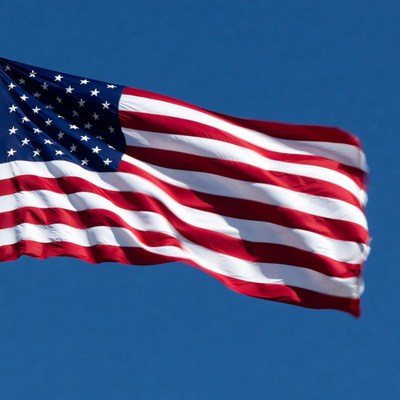 American Flag Waving Against Blue Sky