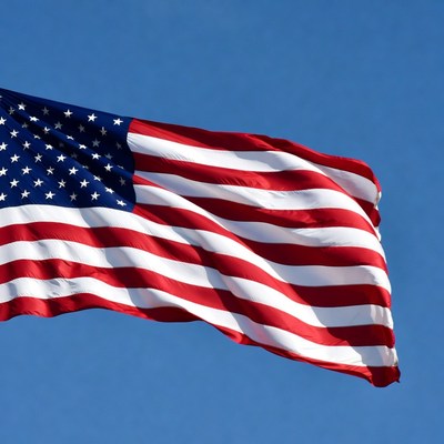 American Flag Waving Against Blue Sky