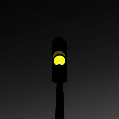Yellow traffic light on black background