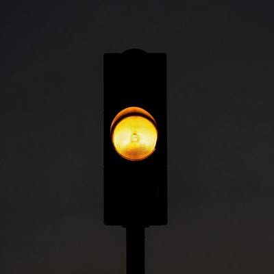 Yellow traffic light glowing at night