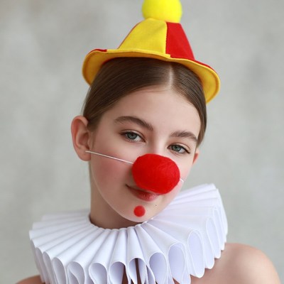 Girl in clown costume with red nose