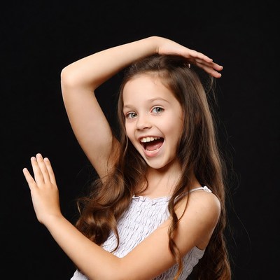 Girl dancing with arms raised