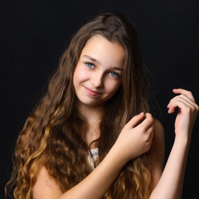 Teen girl with long wavy hair smiling